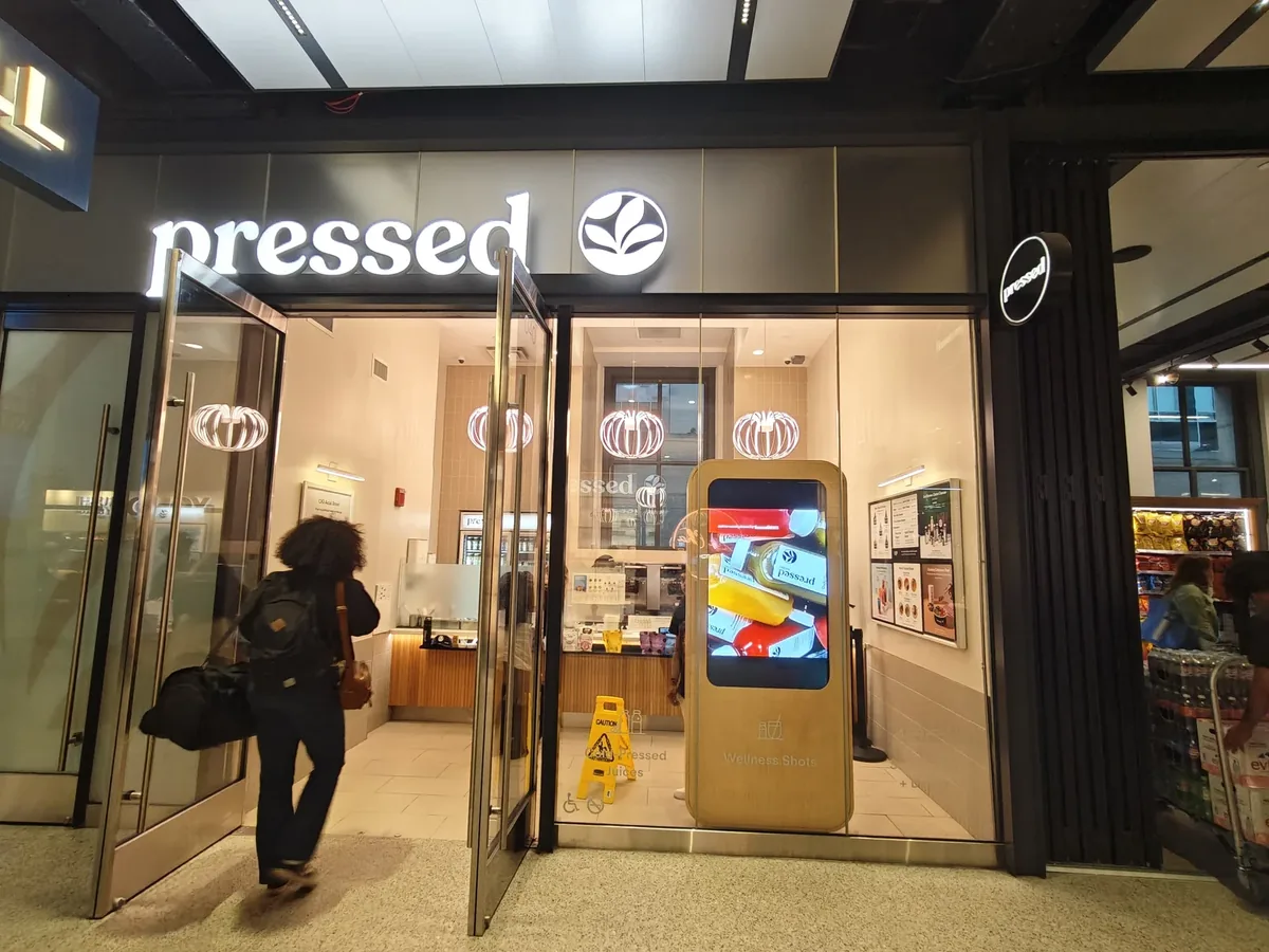 Pressed Juicery Penn Station storefront with a double-sided high-brightness menu kiosk